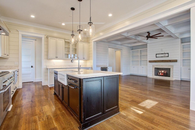 kitchen with an island with sink, dark hardwood / wood-style floors, pendant lighting, sink, and coffered ceiling