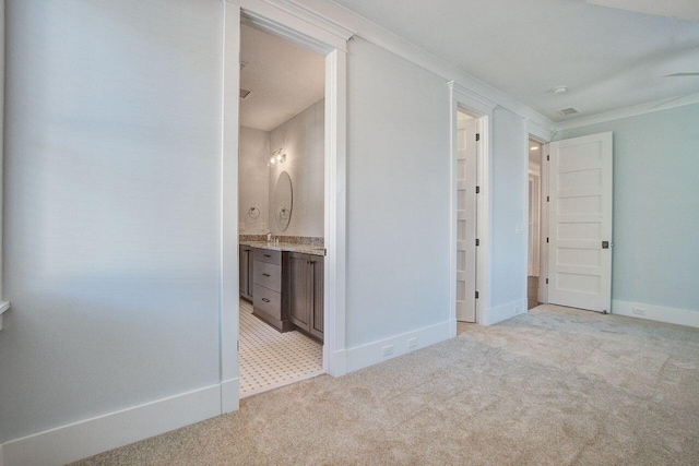 interior space with ornamental molding, light carpet, and ensuite bathroom