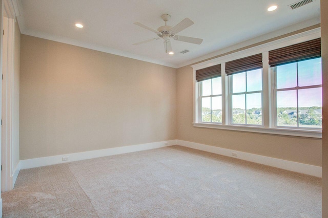 empty room featuring ceiling fan, crown molding, and carpet floors