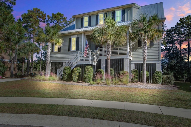 raised beach house featuring a lawn