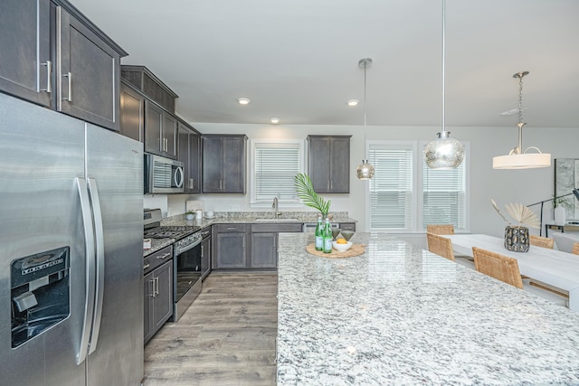 803 Lachicotte Creek Dr, Charleston, SC 29492 - kitchen with hanging light fixtures, light stone countertops, a sink, light wood-style floors, and stainless steel appliances