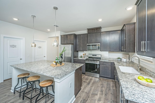 803 Lachicotte Creek Dr, Charleston, SC 29492 - kitchen with dark brown cabinetry, wood finished floors, a kitchen island, a sink, and stainless steel appliances