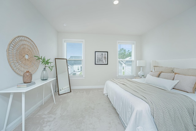 bedroom featuring multiple windows and light colored carpet