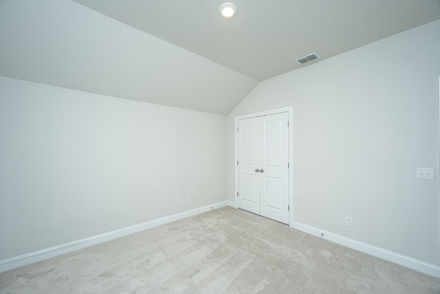 additional living space with vaulted ceiling and light carpet