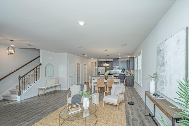 living room featuring wood-type flooring and an inviting chandelier