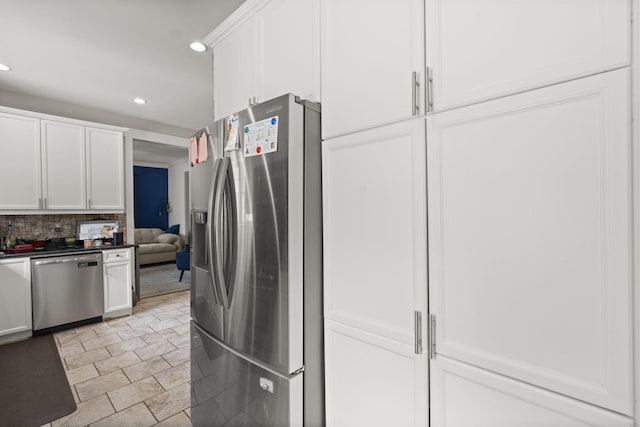 kitchen featuring dark countertops, recessed lighting, white cabinetry, tasteful backsplash, and stainless steel appliances