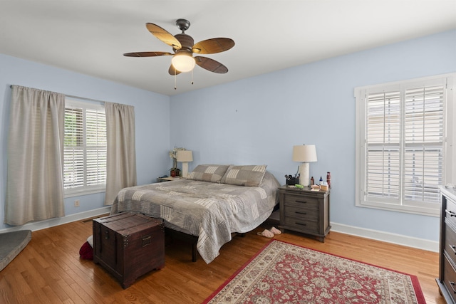 bedroom featuring baseboards, light wood finished floors, and ceiling fan