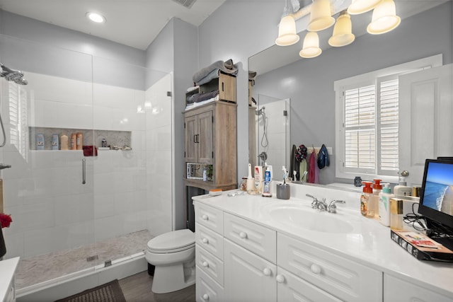 bathroom with vanity, an inviting chandelier, visible vents, toilet, and a shower stall