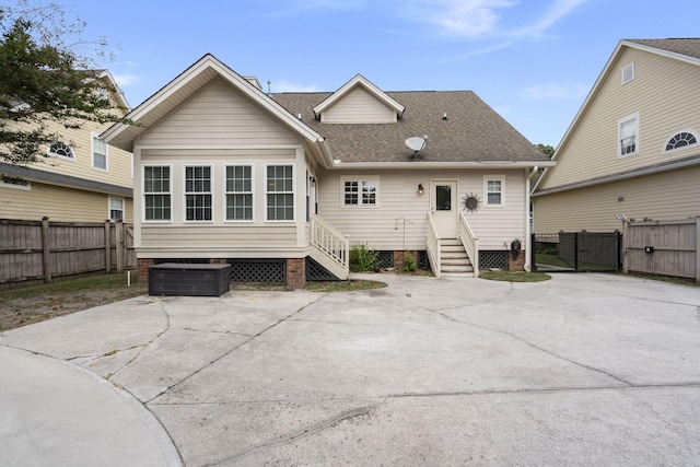 back of property featuring fence, roof with shingles, a gate, a patio area, and crawl space