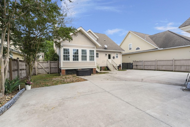 back of house with a patio, a fenced backyard, a gate, a shingled roof, and concrete driveway