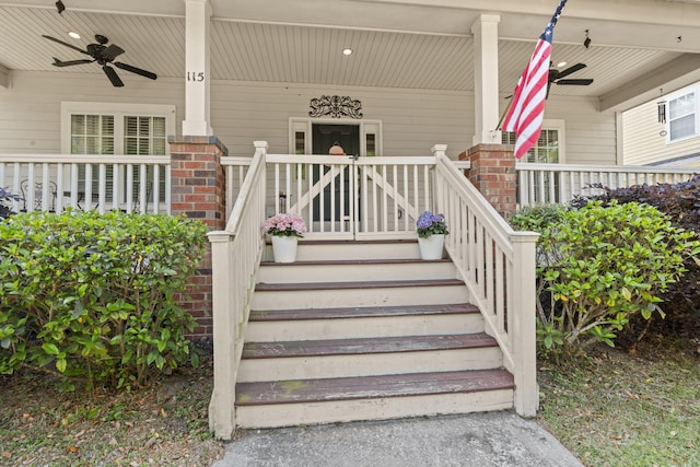 view of exterior entry with a porch, brick siding, and a ceiling fan