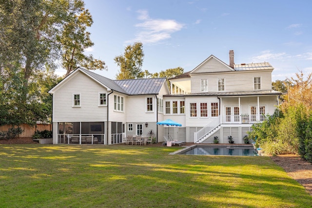 back of house featuring a lawn and solar panels