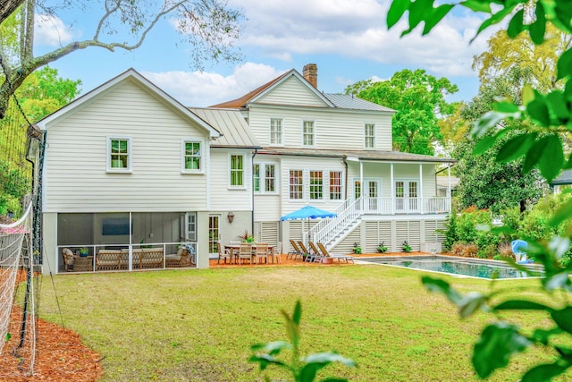 back of house with a patio, a sunroom, and a lawn