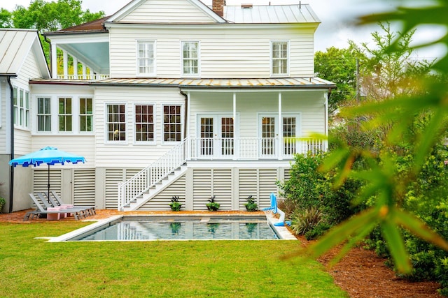 rear view of house featuring a yard