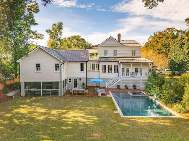 rear view of property with a patio and a lawn