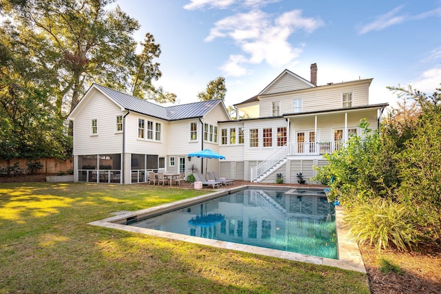 back of house featuring a swimming pool side deck and a yard