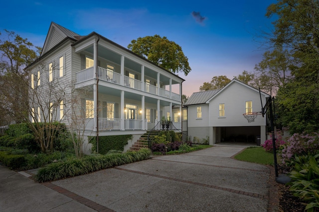 view of front facade with a balcony, a porch, and a carport