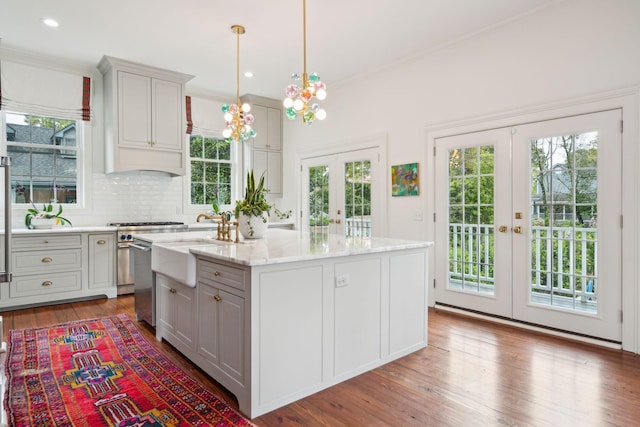 kitchen featuring gray cabinets, a kitchen island, light stone countertops, and french doors