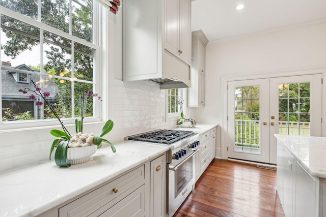 kitchen featuring french doors, backsplash, high end stainless steel range oven, dark wood-type flooring, and white cabinets