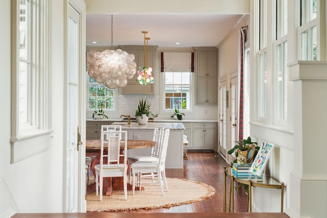 kitchen featuring a chandelier, gray cabinetry, decorative backsplash, and hanging light fixtures