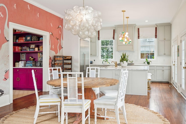 dining room featuring a chandelier, wood-type flooring, and crown molding