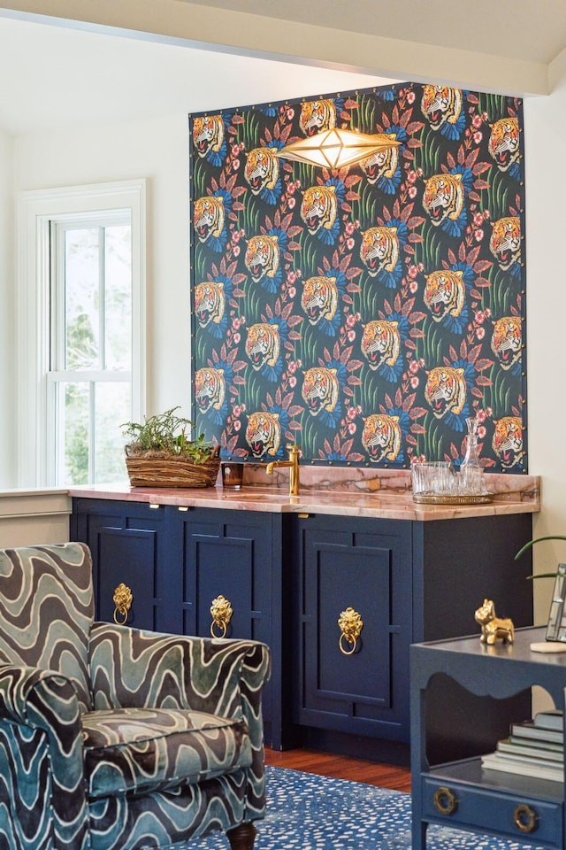 interior details with bar and hardwood / wood-style flooring