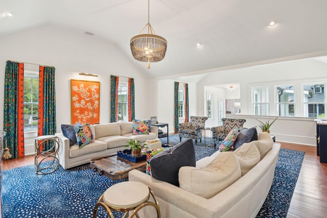 living room with hardwood / wood-style flooring, vaulted ceiling, and a notable chandelier