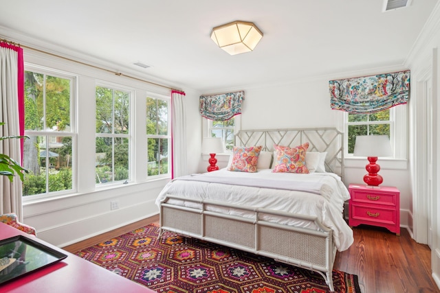 bedroom featuring crown molding and dark wood-type flooring