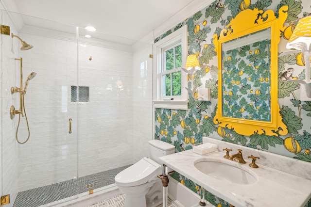 bathroom with vanity, toilet, a shower with shower door, and crown molding