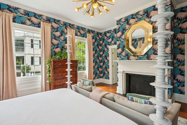 bedroom with hardwood / wood-style floors, ornamental molding, and a chandelier