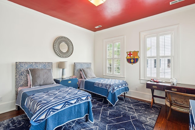 bedroom with dark hardwood / wood-style flooring and crown molding