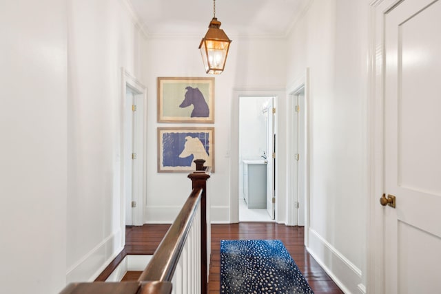 corridor with ornamental molding and dark wood-type flooring