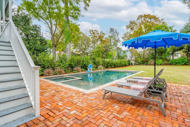 view of pool with a patio area, a yard, and an in ground hot tub