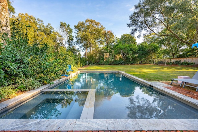 view of swimming pool featuring an in ground hot tub and a yard