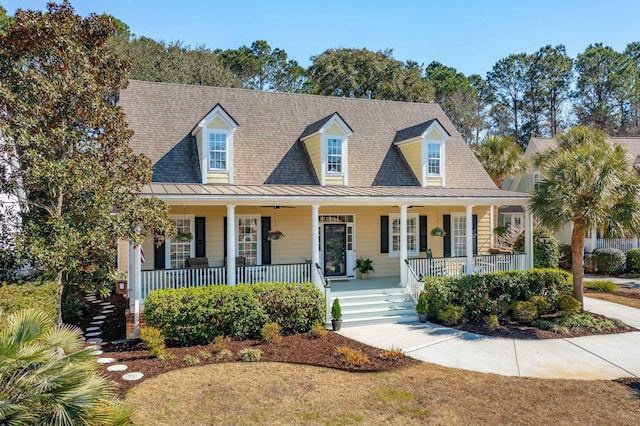 cape cod house featuring covered porch, metal roof, a shingled roof, and a standing seam roof