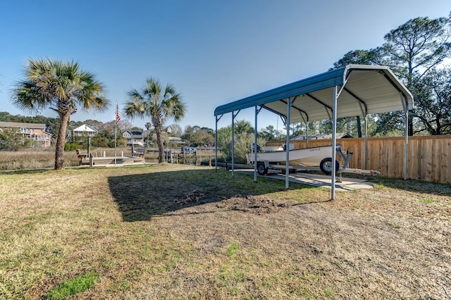 view of yard with a carport and fence