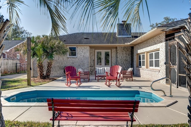 view of pool featuring french doors, a patio area, a fenced in pool, and fence