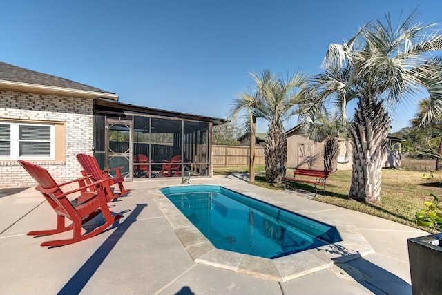 view of pool with fence, a shed, a sunroom, an outdoor structure, and a patio area