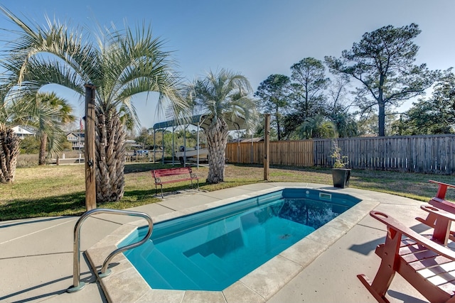 view of swimming pool with a yard, a patio area, and fence