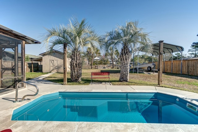 view of pool featuring an outbuilding, a lawn, fence, a storage shed, and a fenced in pool