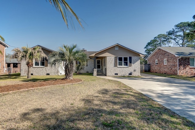 view of front of house with crawl space, brick siding, a front yard, and fence