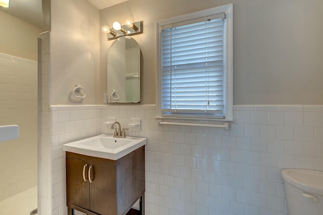 full bathroom featuring vanity, tile walls, toilet, and a stall shower