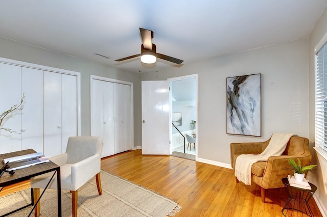 office space featuring visible vents, baseboards, ceiling fan, and wood finished floors