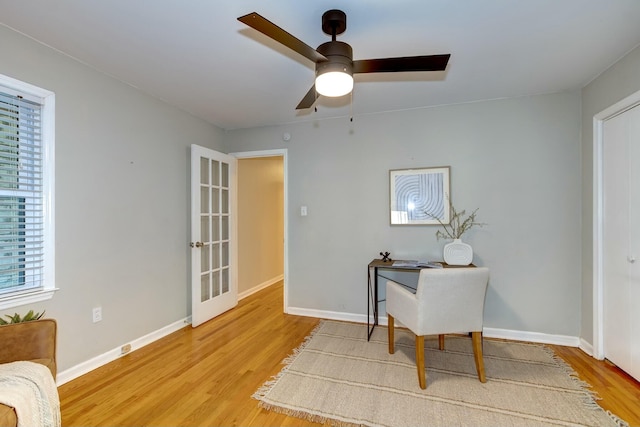 office space featuring baseboards, light wood-style floors, and a ceiling fan