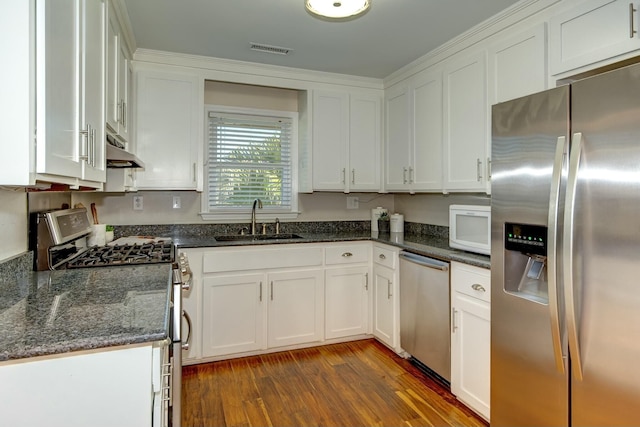 kitchen featuring under cabinet range hood, white cabinetry, stainless steel appliances, and a sink