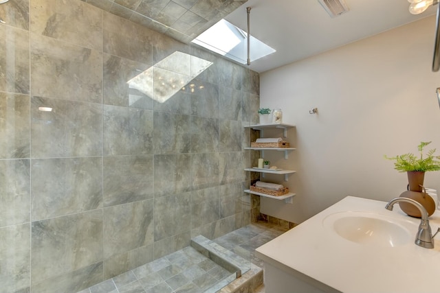 full bathroom featuring a sink, visible vents, a skylight, and a tile shower