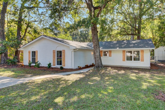 single story home with a storage shed and a front yard