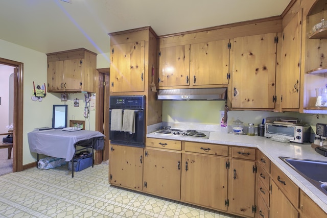 1430 Brian Rd, Charleston, SC 29407 - kitchen with black oven, stainless steel cooktop, under cabinet range hood, light countertops, and brown cabinetry