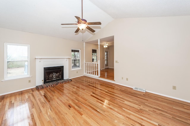 unfurnished living room featuring light wood-type flooring, lofted ceiling, and a fireplace