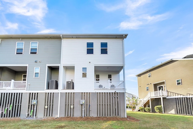 rear view of property with a yard and central AC